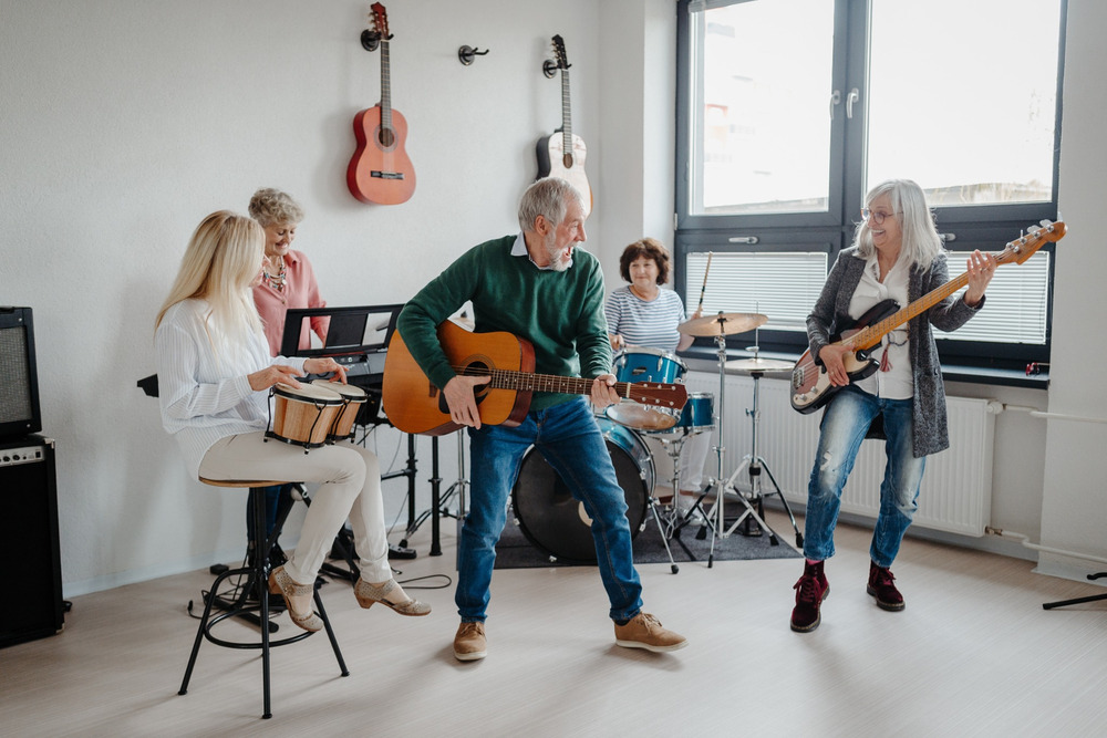 A group of people in their 50s playing musical instruments in a band.