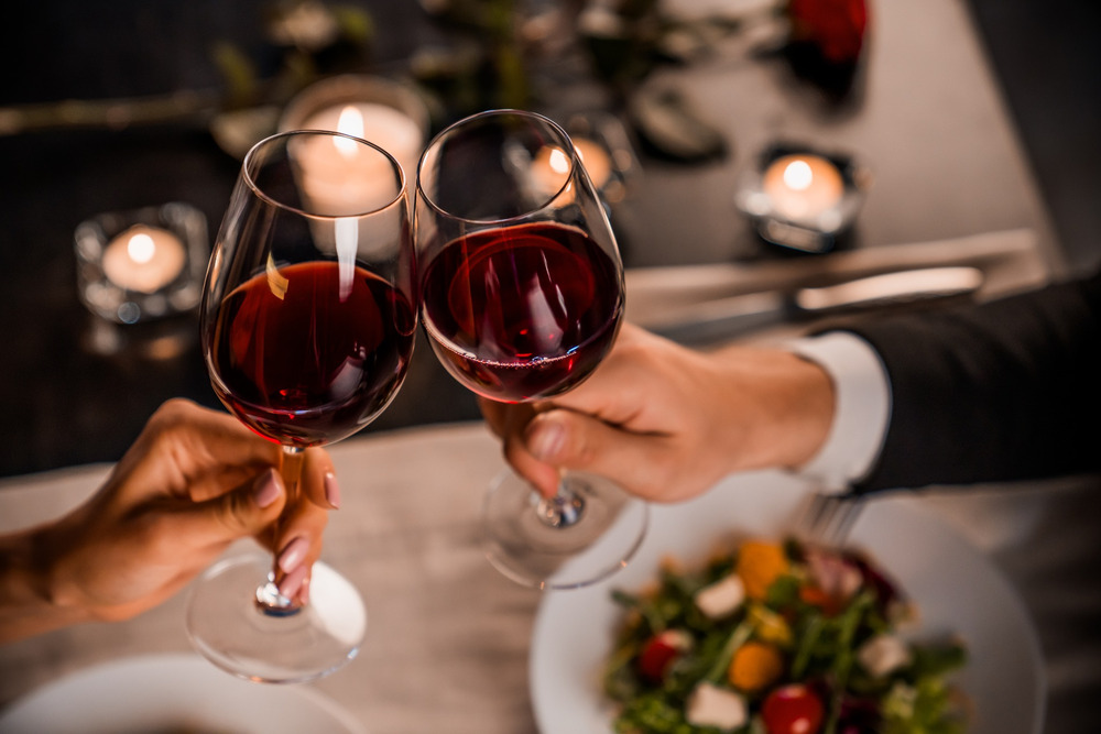 A couple toasting with wine glasses.