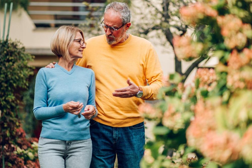 Mature couple walking outside a house