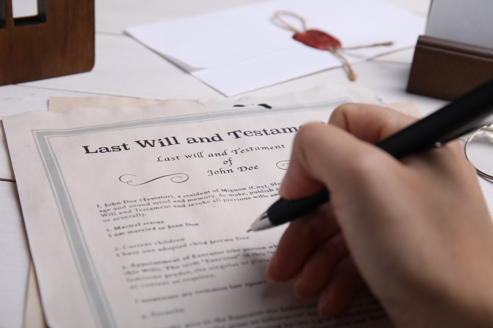 A person signing a will.