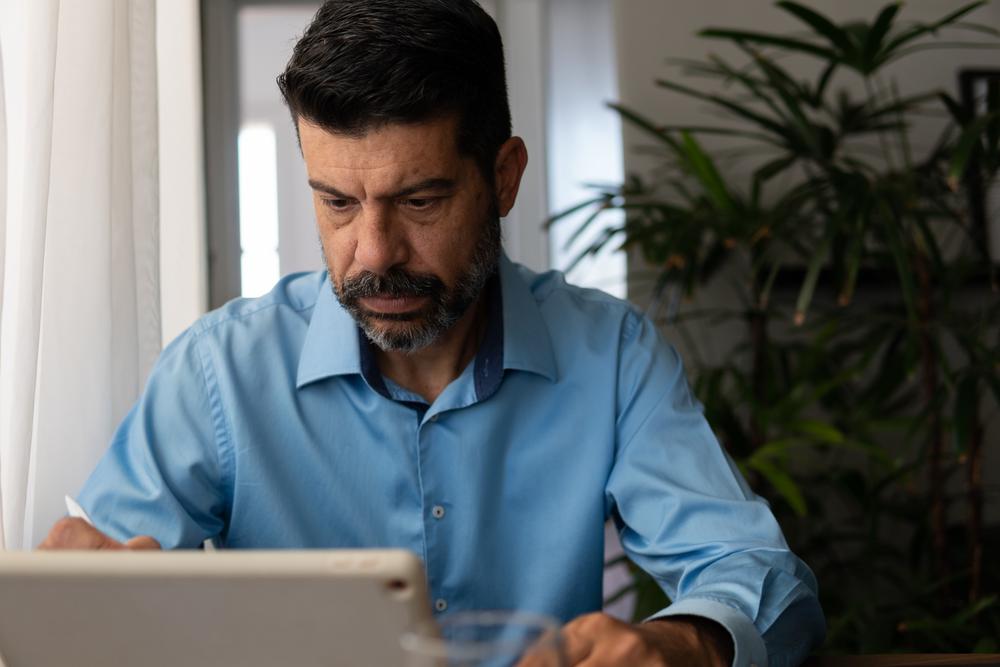A man looking at a tablet screen.