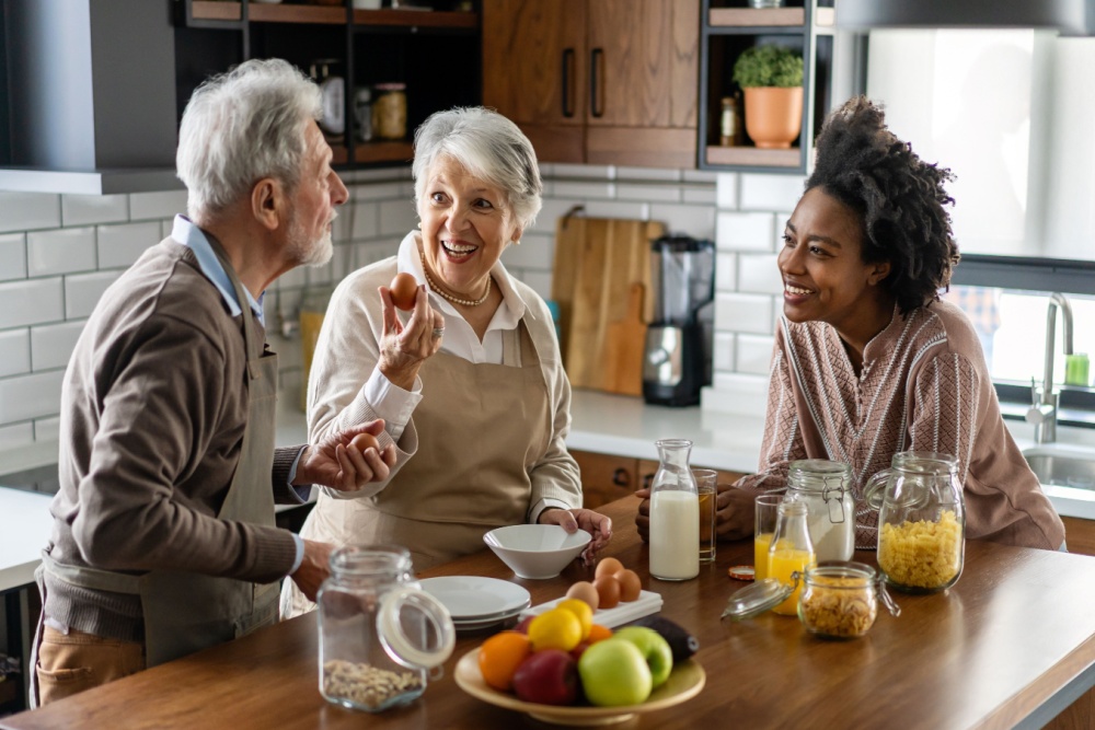 Parents talking to their adult child in their kitchen.