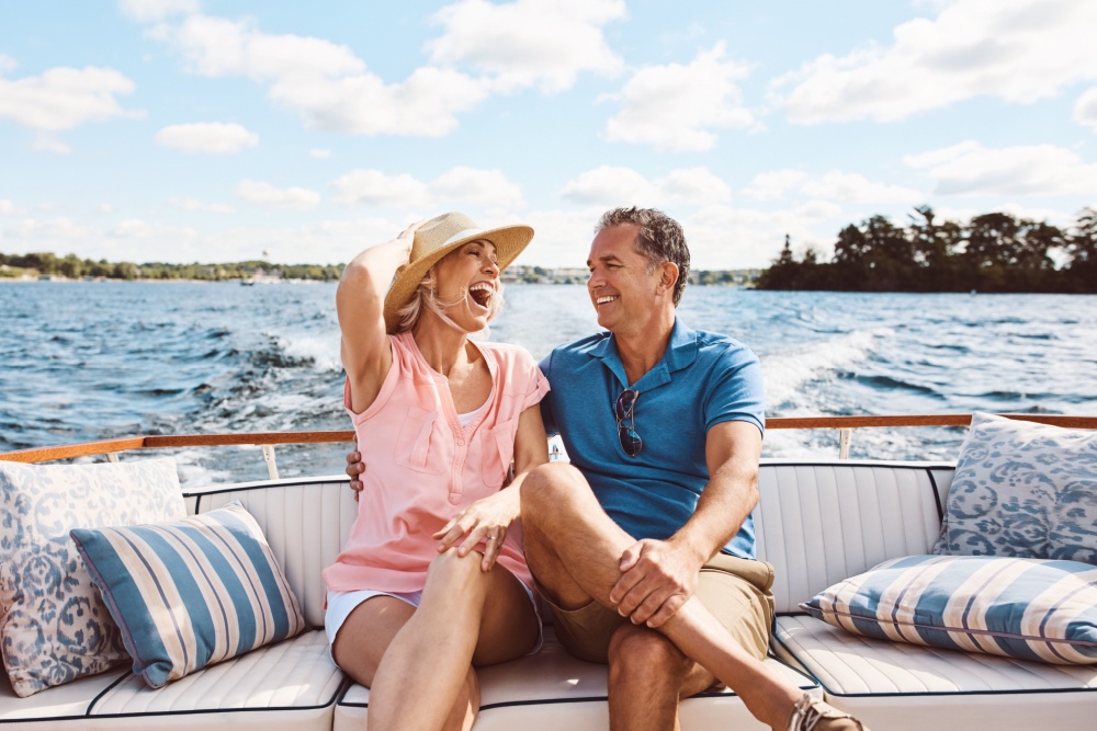 A couple in their 50s laughing on a boat together.