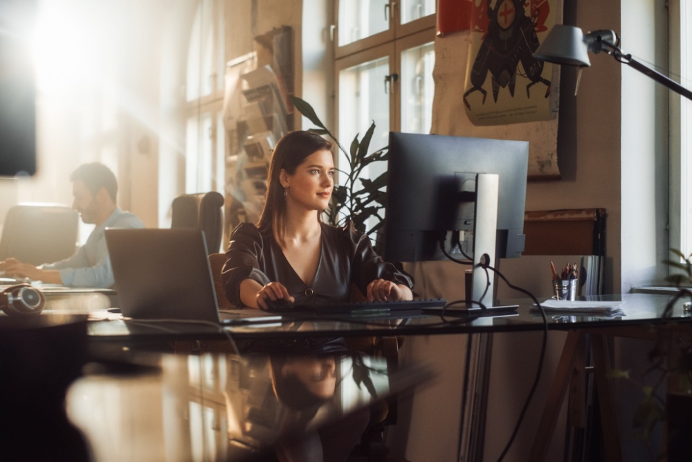 A woman using a computer in an office.